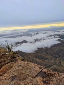 Big Bend National Park 4 Panoramic view from atop a cliff, looking out over a rugged landscape with low-lying clouds.