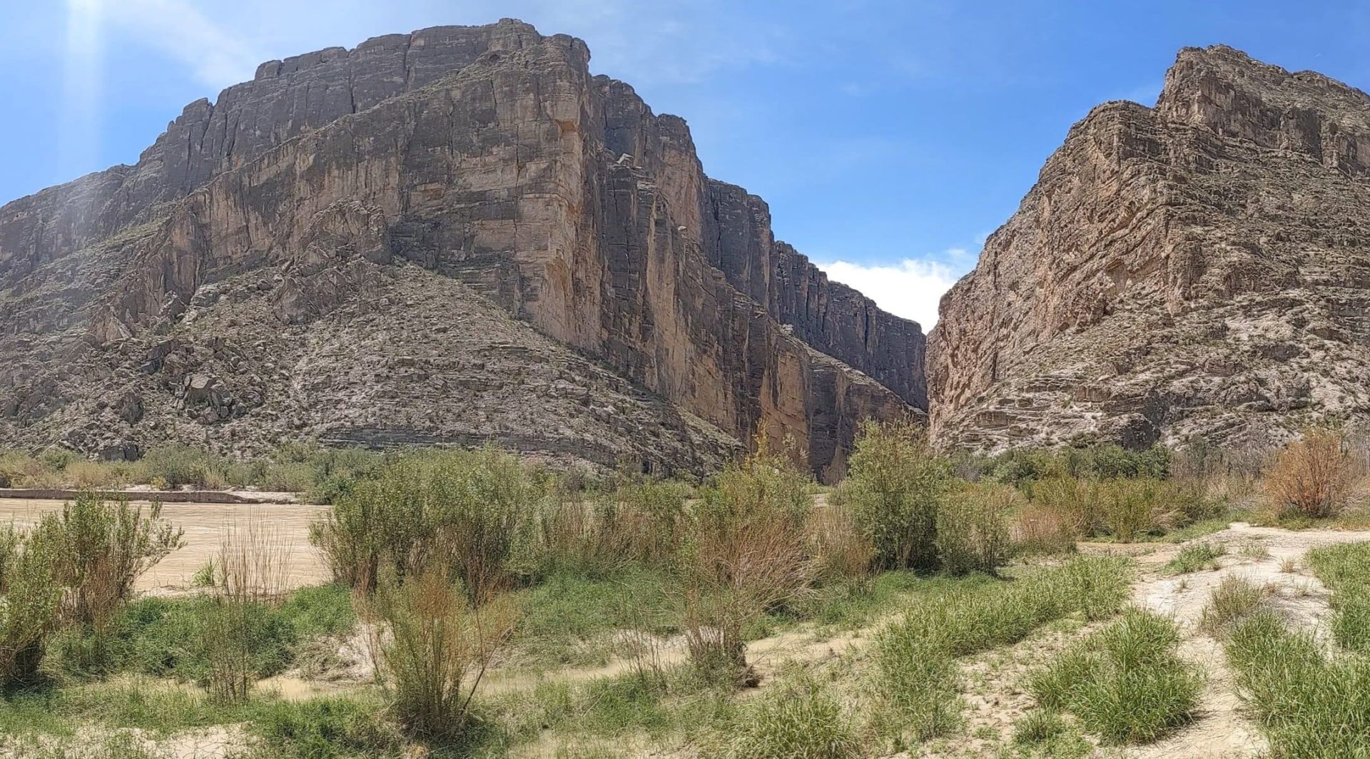 The massive cliffs of a canyon open onto the Rio Grande