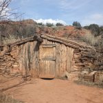 A wooden dugout cabin alongside the trail